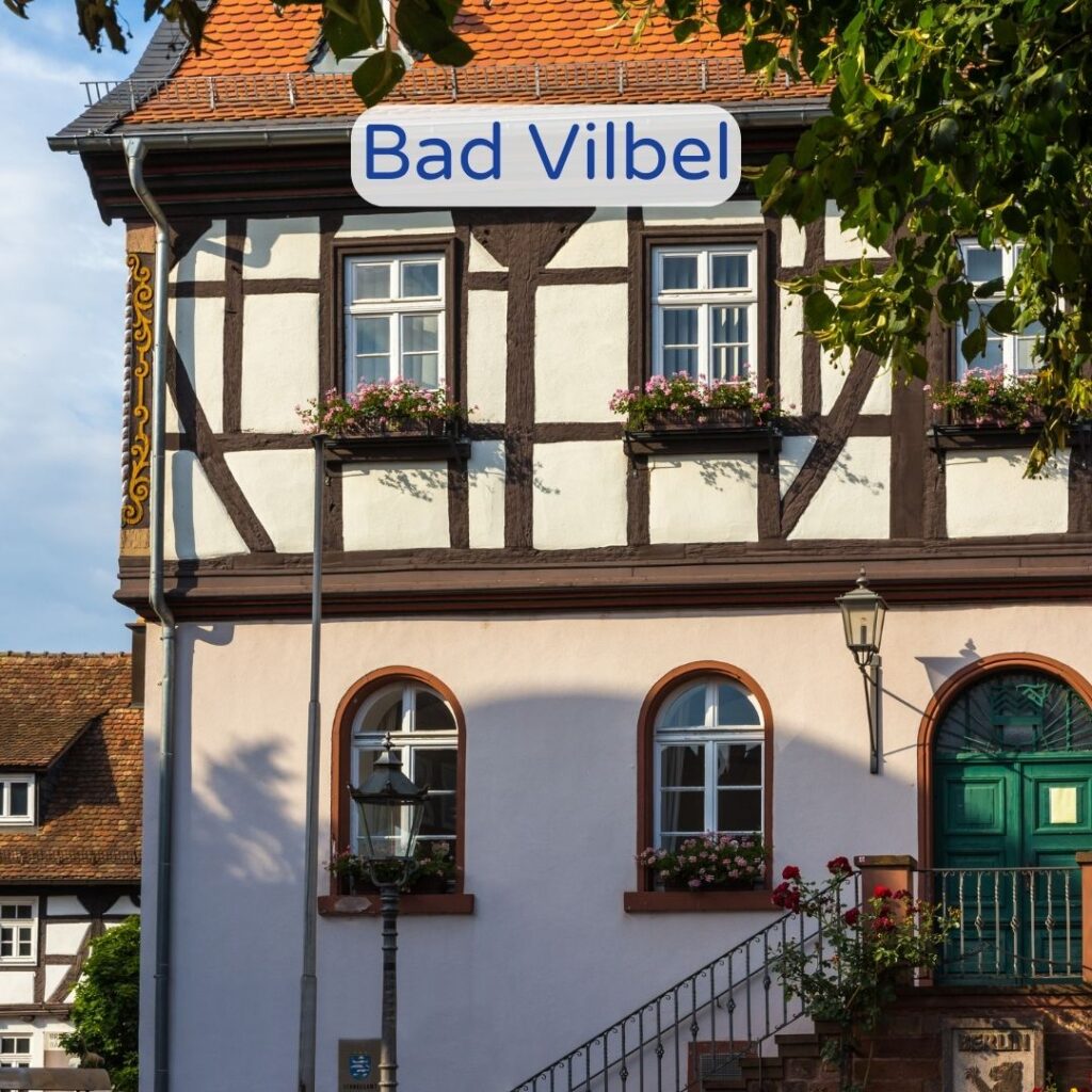 Saniertes Fachwerkhaus in Bad Vilbel mit blumengeschmückten Fensterläden.